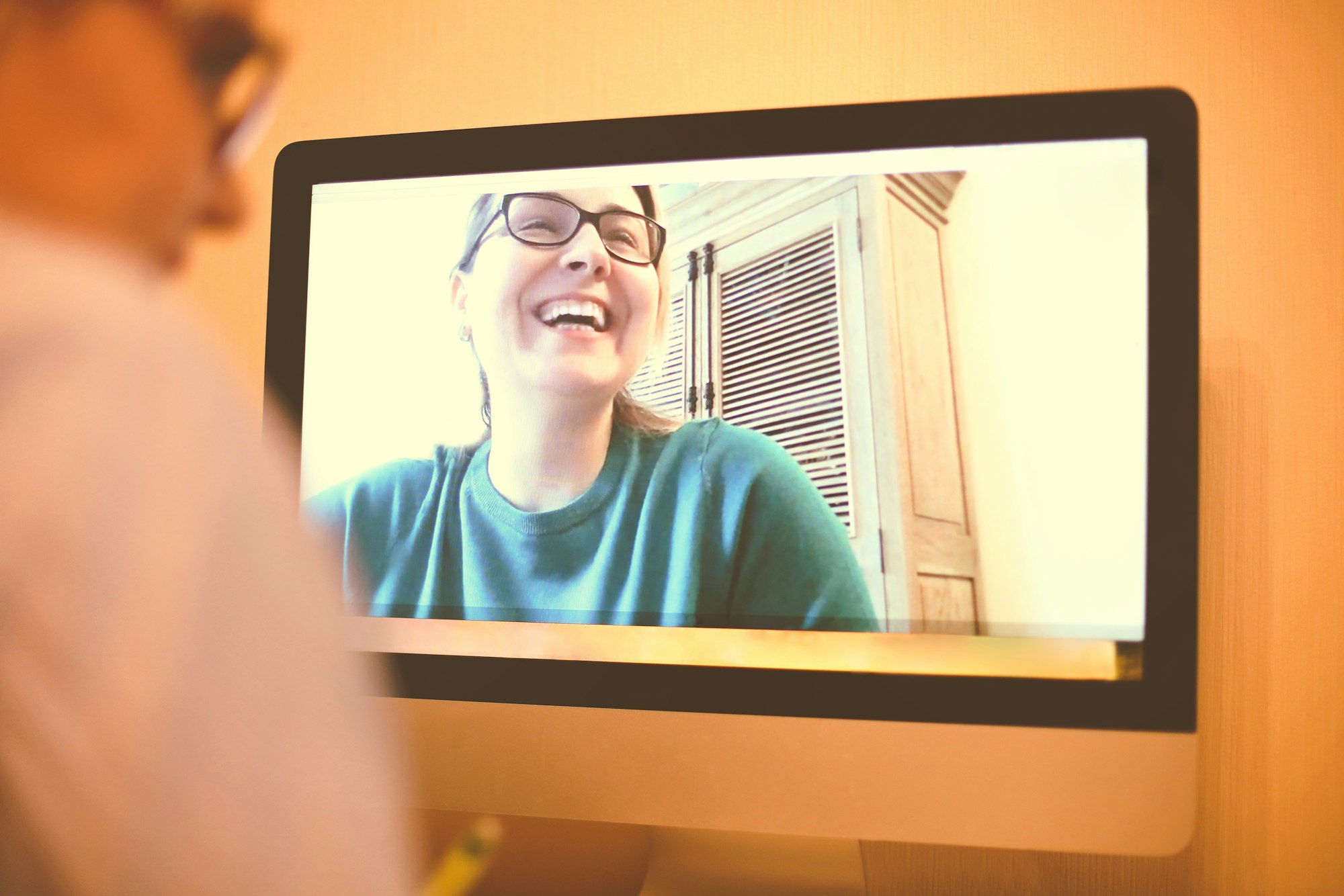 Content female friends having video call on Internet via computers and speaking remotely during COVI