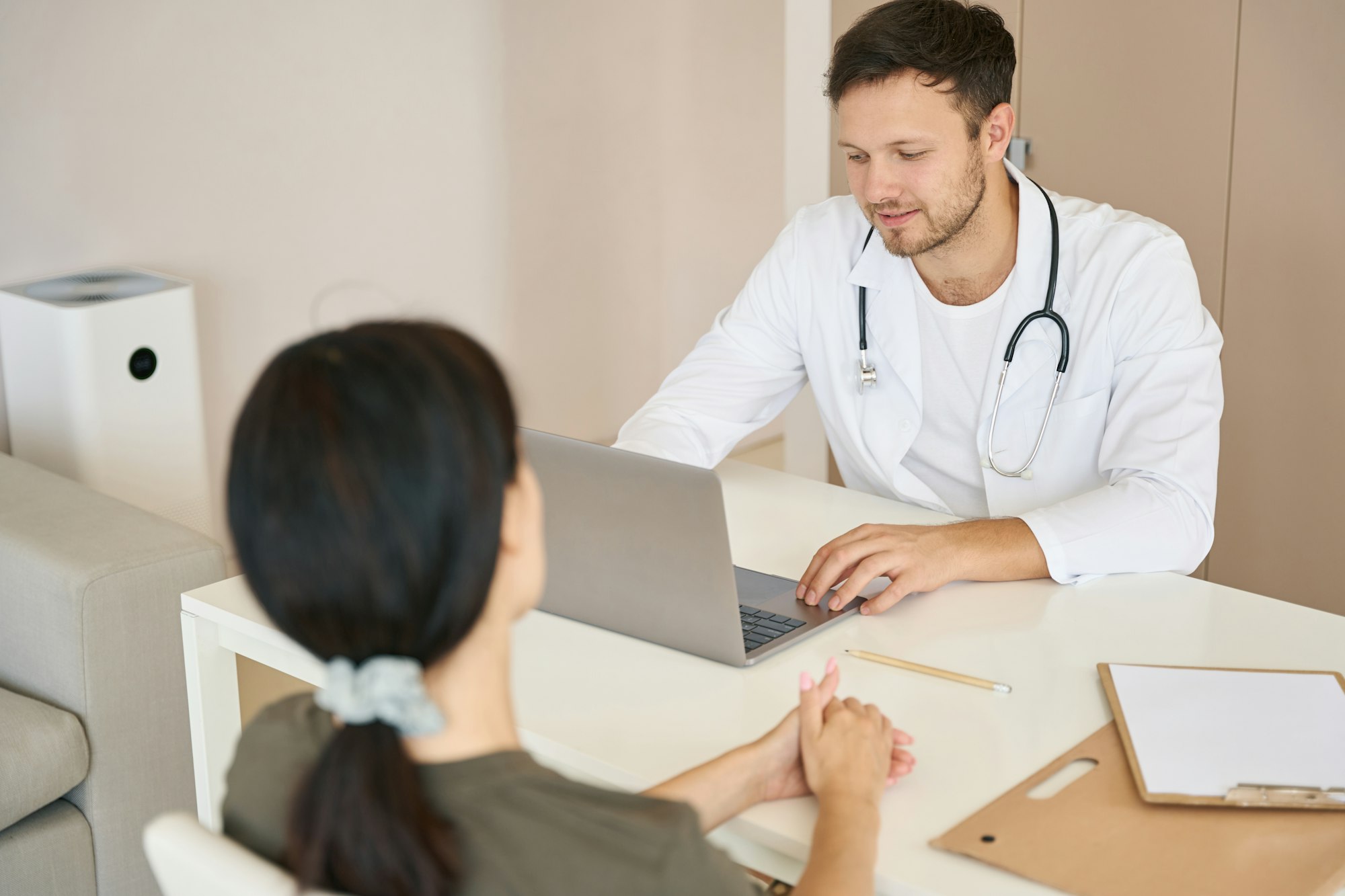 Doctor with a phonendoscope interrogates a patient about health problems