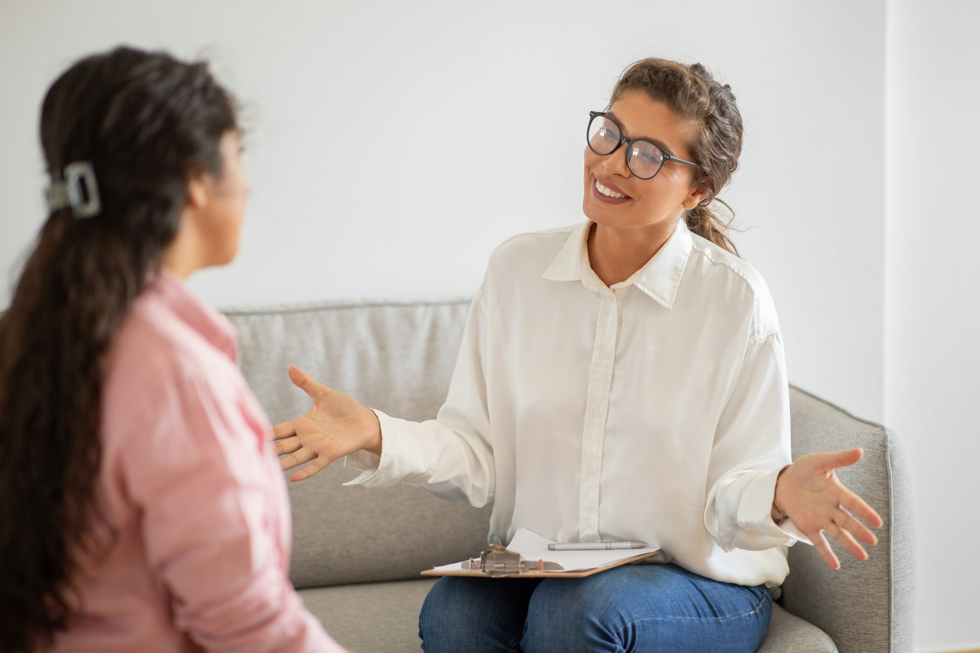 Friendly woman wearing glasses counseling young lady