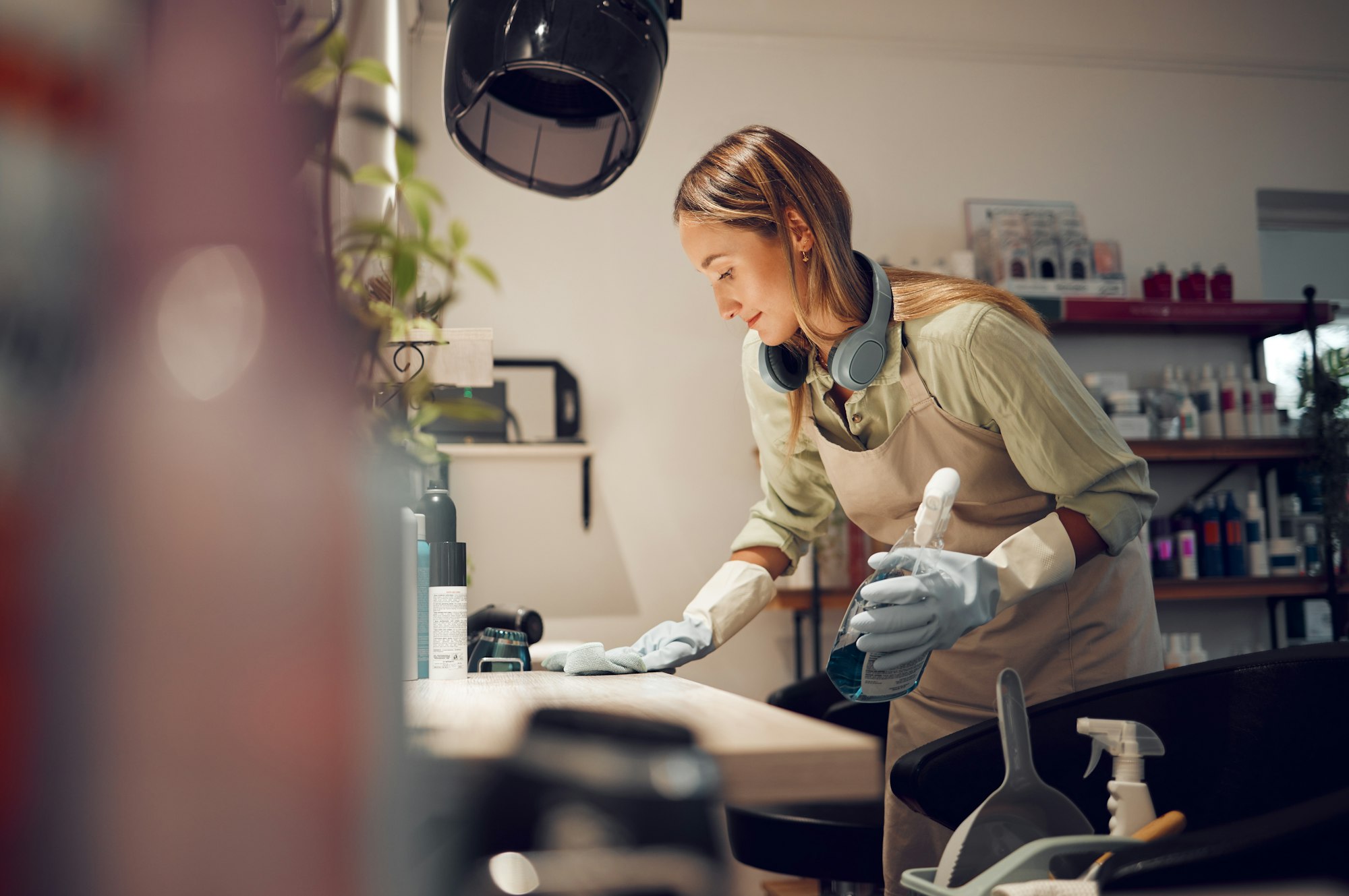 Hair salon, cleaner and woman cleaning a workplace in Australia with equipment and headphones. Hous