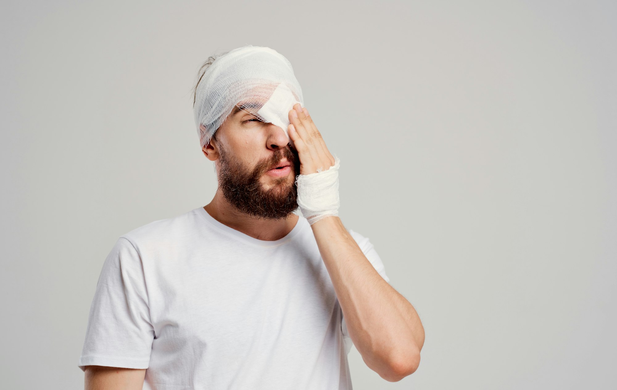 male patient head injury in white t-shirt headache light background