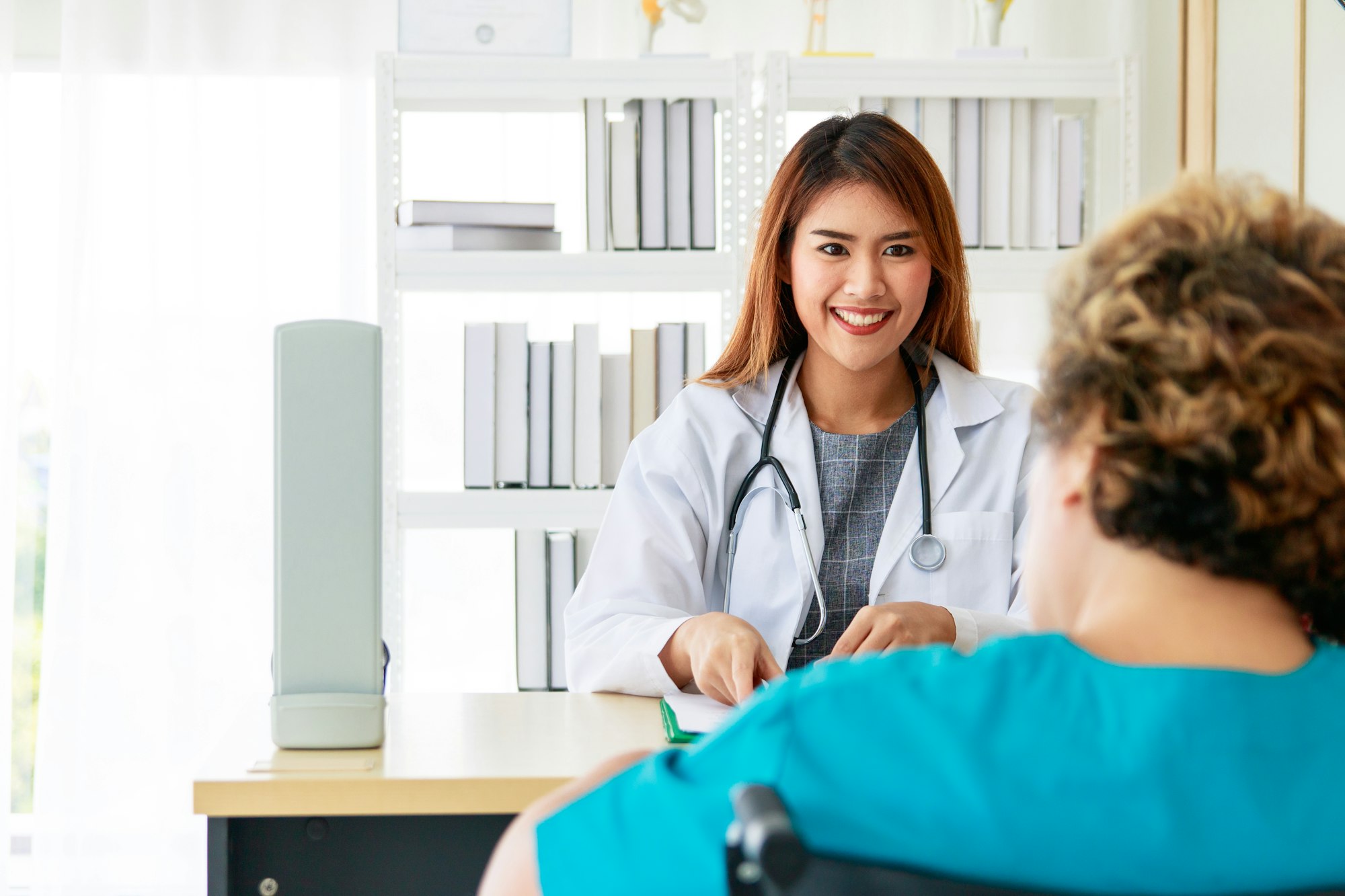 Portrait of a beautiful Asian woman doctor smiling and interviewing the patient's symptoms.